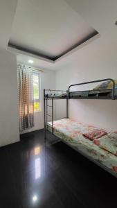 1 dormitorio con 2 literas y ventana en Finteo Skylands, en Baguio