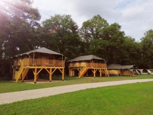 un par de cabañas en un campo con árboles en Goorzicht, en Aalten