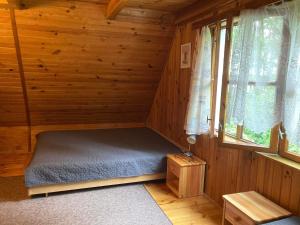 a room with a bed in a log cabin at Dom pod Sosnami in Narty