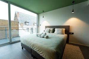 een slaapkamer met een groot bed en een groot raam bij Green Appart - A&B Best Quality - Mons City Center in Bergen