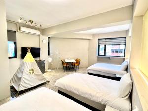 市中心民宿-大床有電梯&近東大門夜市 في مدينة هوالين: غرفة بسريرين وطاولة مع خيمة