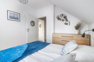 a white bedroom with a bed with a blue blanket at Statki Na Niebie in Rowy