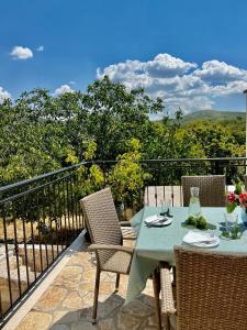 a table and chairs on a balcony with a view at Vikendica Oliver in Medovdolac