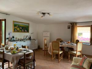 ein Wohnzimmer mit 2 Tischen und eine Küche in der Unterkunft La Tenuta B&B in Buonvicino