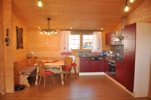 a kitchen with red cabinets and a table with chairs at Ferienhaus Altmann 1 in Sankt Magdalena