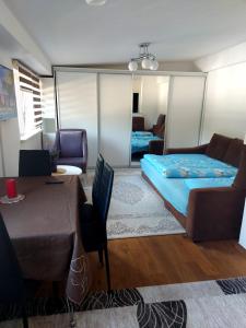 a bedroom with a bed and a couch and a table at Indy in Travnik