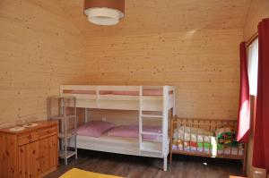 ein Schlafzimmer mit Etagenbetten in einem Blockhaus in der Unterkunft Ferienhaus Altmann 2 in Sankt Magdalena