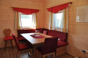 a dining room with a wooden table and red chairs at Ferienhaus Altmann 2 in Sankt Magdalena