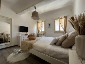 een witte slaapkamer met een groot bed en een televisie bij La Piccola Maison in Florence