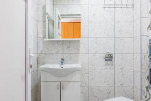 Baño blanco con lavabo y espejo en Vila Peristeron, en Golubac