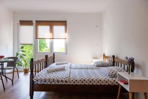 1 dormitorio con 2 camas, mesa y sillas en Vila Peristeron, en Golubac