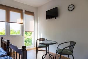 a room with a table and two chairs and a clock at Vila Peristeron in Golubac