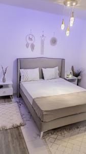 una camera da letto con un grande letto con pareti viola di Ideal Appart El Wahat VIP a El Aouina