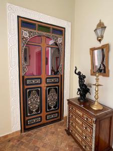 een kamer met een grote houten deur met een spiegel bij Riad Ksar Al Amal in Marrakesh