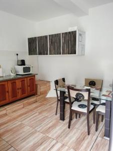 een keuken met een tafel en stoelen en een aanrecht bij Loversnest Self Catering in Anse aux Pins