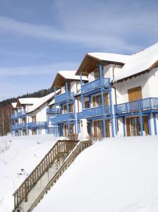 ein blau-weißes Gebäude im Schnee in der Unterkunft Appartements Sonnenwald in Unterlangfurth