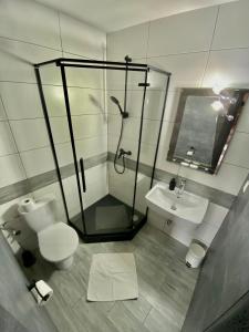 a bathroom with a shower and a toilet and a sink at Penzión DOMES in Čadca