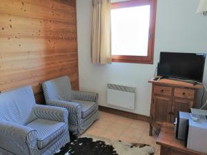 a living room with two chairs and a flat screen tv at Appartement Morillon 1100, 3 pièces, 6 personnes - FR-1-412-5 in Morillon