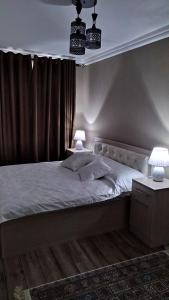 a bedroom with a bed with two lamps on it at Apartment near Farkhadskiy bazar in Tashkent