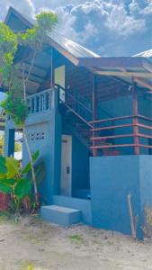 a blue building with a staircase in front of it at Shat's Guest House in General Luna
