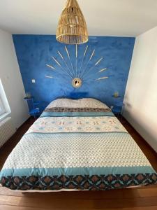 um quarto com uma cama com uma parede azul em La Maison d’Alie (Alie’s Home) em Boulogne-sur-Mer