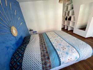 1 dormitorio con 1 cama con pared azul en La Maison d’Alie (Alie’s Home), en Boulogne-sur-Mer