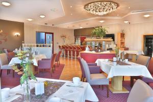 ein Speisesaal mit Tischen und Stühlen und ein Restaurant in der Unterkunft Hotel Kristall in Weißwasser