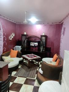 a living room with purple walls and couches at App11- BELAL - Enjoy the privacy of staying in a quiet apartment with free Wi-Fi as your complete second home in the heart of Hurghada in Hurghada
