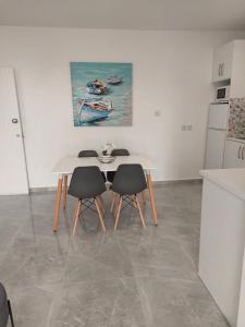 a white table and two chairs in a kitchen at Amazing Napa Apartment in Ayia Napa