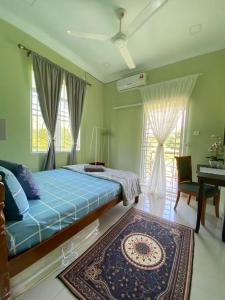 a bedroom with a bed and a rug and a piano at Darney's Homestay Kg Bangau Tanjung in Temerloh