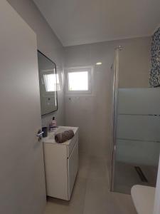 a white bathroom with a sink and a shower at Amazing Napa Apartment in Ayia Napa