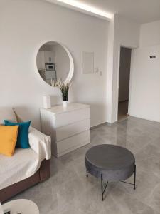 a living room with a couch and a table and a mirror at Amazing Napa Apartment in Ayia Napa