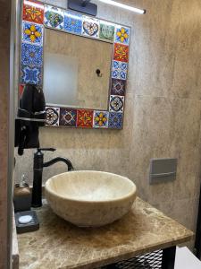 y baño con lavabo de piedra y espejo. en Kasri Mezopotamya, en Midyat