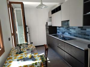 eine kleine Küche mit einem Tisch und einer Küchentheke in der Unterkunft appartamento in piccolo borgo immerso nel verde in Castiglione Chiavarese
