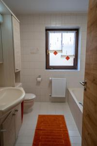 ein Bad mit einem Waschbecken, einem WC und einem Fenster in der Unterkunft Ferienwohnung-Kappl in Tännesberg