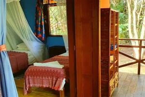 um quarto com uma cama, um espelho e uma janela em Casa Vilacentro - Imbassaí em Imbassaí