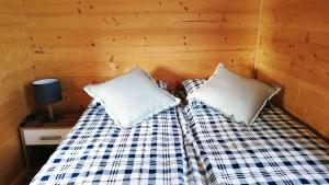 a bed in a room with two pillows on it at Domki Na Stoku Laworty in Ustrzyki Dolne