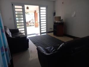 uma sala de estar com dois sofás e uma televisão em Hostel Ohana Beach em Mongaguá