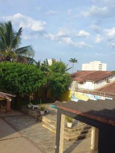 uitzicht op een zwembad met bomen en gebouwen bij Hostel Ohana Beach in Mongaguá