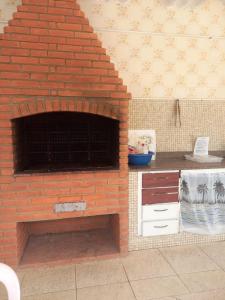 a brick oven in a kitchen with a counter at Hostel Ohana Beach in Mongaguá