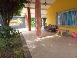 een patio met stoelen en tafels in een gebouw bij Hostel Ohana Beach in Mongaguá