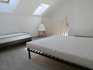 - une chambre avec un lit blanc et une chaise dans l'établissement Maisonnette 40 m2 pour 5 personnes, à Paray-le-Monial