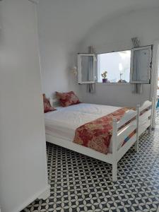 a white bed in a room with a window at Dar Fatma in Hammamet