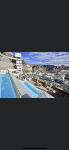 uma vista para uma piscina com uma cidade ao fundo em Monsenor em Playa del Cura