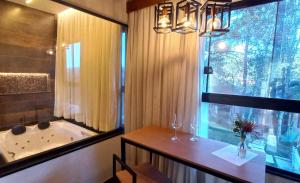 蒙特韦尔迪Terrace Chalés的带浴缸、水槽和窗户的浴室