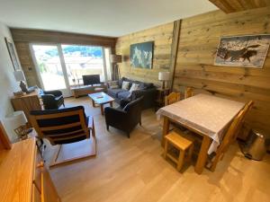 拉克吕萨Appartement 2 pièces ensoleillé avec Wi-Fi et parking, La Clusaz - FR-1-459-76的客厅里有一张桌子和一张沙发