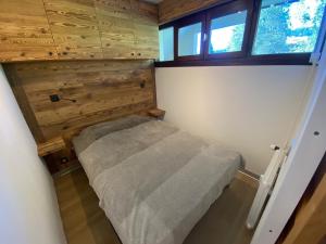 een kleine slaapkamer met een bed in een huis bij Appartement La Clusaz, 2 pièces, 6 personnes - FR-1-459-76 in La Clusaz