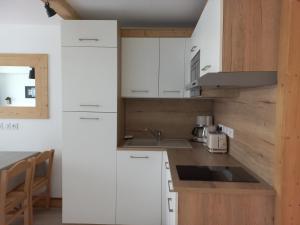 - une cuisine avec des placards blancs et un évier dans l'établissement Studio Tignes, 1 pièce, 4 personnes - FR-1-449-72, à Tignes