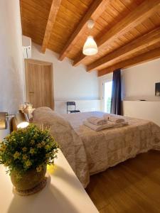 a bedroom with a bed and a table with a plant at B&B Pelagos in Castellammare del Golfo