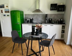 uma cozinha com uma mesa e cadeiras e um frigorífico verde em Appartement Louis em Oberammergau